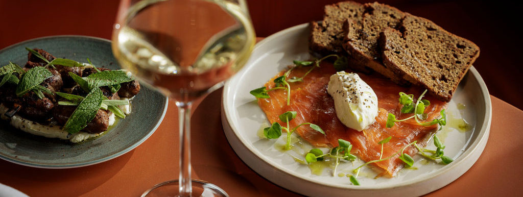 Close-up of a set lunch table with food and a glass of wine